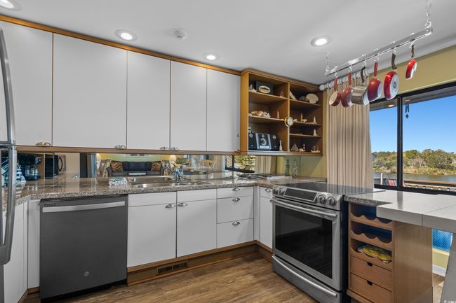 Kitchen with white cabinets, visible vents, stainless steel appliances, and dark wood finished floors | Image 16