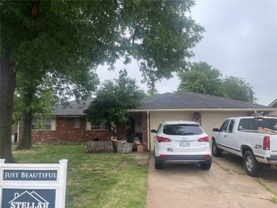 Single story home featuring a garage and a front lawn | Image 1