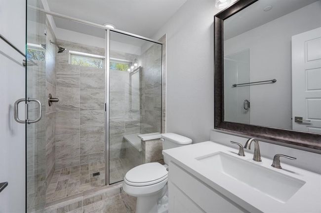 Bathroom with toilet, a stall shower, and vanity | Image 28