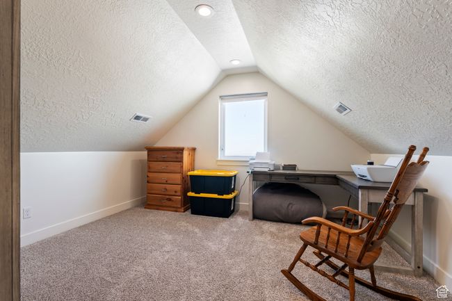 Interior space with a textured ceiling, vaulted ceiling, baseboards, visible vents, and carpet floors | Image 27
