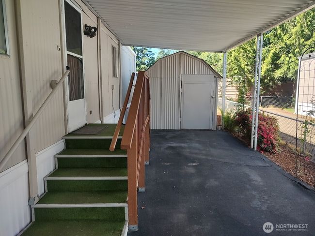 Long driveway leading up to a large shed | Image 5