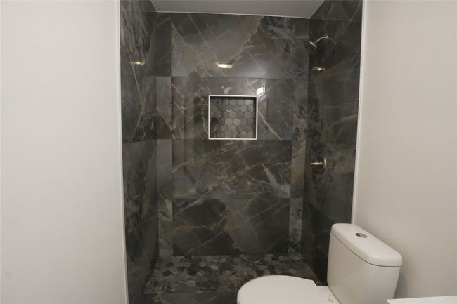 Full bath featuring a tile shower and toilet | Image 16
