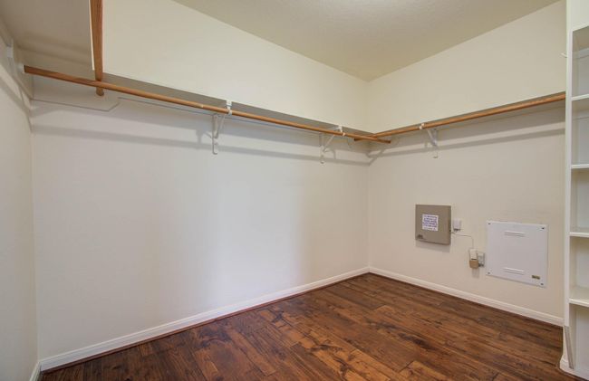 Spacious primary closet has shelves and tons of hanging space. | Image 24