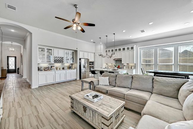 High ceilings and neutral tones flood the living room with natural light, enhancing the inviting atmosphere. | Image 5