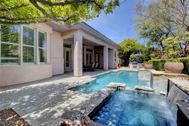 View of swimming pool with a ceiling fan, a pool with connected hot tub, and a patio area | Image 46