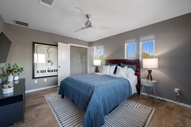Bedroom with wood finished floors, baseboards, and visible vents | Image 17