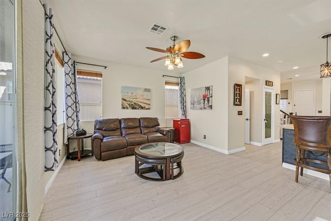 Living room with light wood-type flooring, visible vents, a ceiling fan, recessed lighting, and baseboards | Image 12