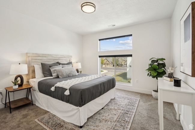 Bedroom with visible vents, carpet flooring, and access to outside | Image 23