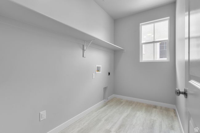 Laundry area with electric dryer hookup, light wood-style floors, and washer hookup | Image 12