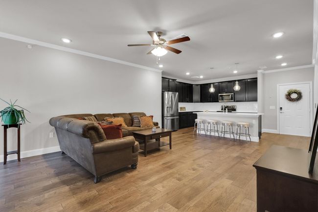 Living room with crown molding, ceiling fan, recessed lighting, light wood finished floors, and baseboards | Image 8