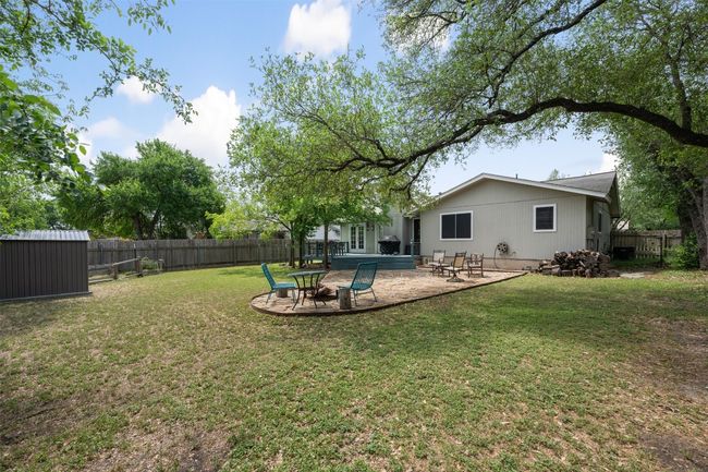 View of yard featuring a patio area, a fenced backyard, an outbuilding, and a storage shed | Image 26