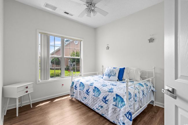 Bedroom with wood finished floors, baseboards, and ceiling fan | Image 27