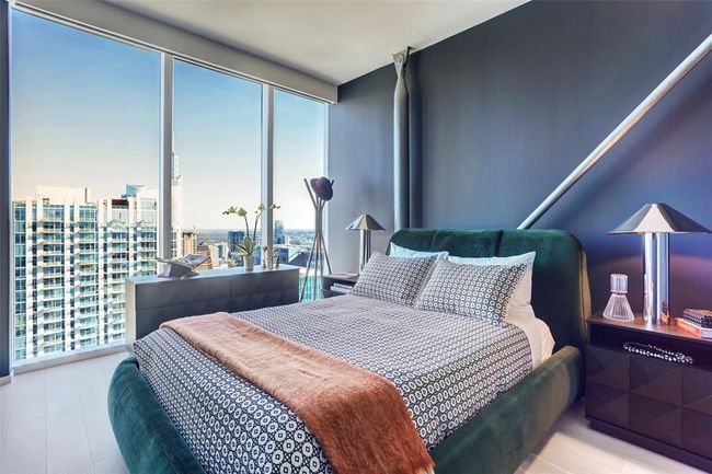 Bedroom featuring multiple windows, expansive windows, and a view of city | Image 12