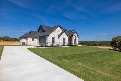 French country home with a garage, a front lawn, and central AC | Image 2