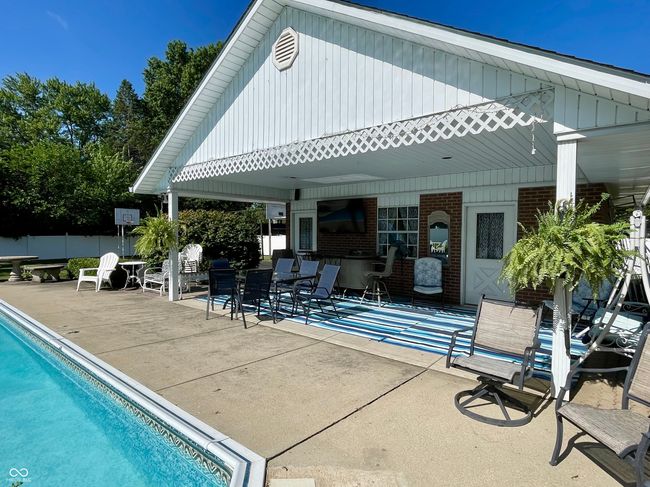 swimming pool featuring a patio area and pool house/garage with bath with shower, vanity & toilet | Image 14