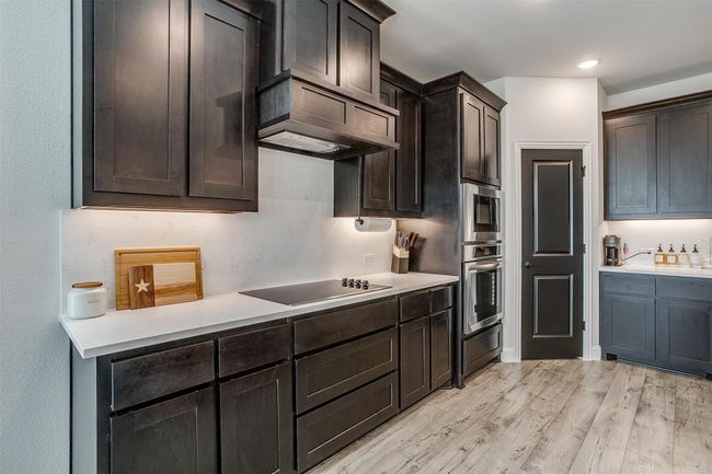 Kitchen with appliances with stainless steel finishes, light wood-type flooring, and dark brown cabinets | Image 5