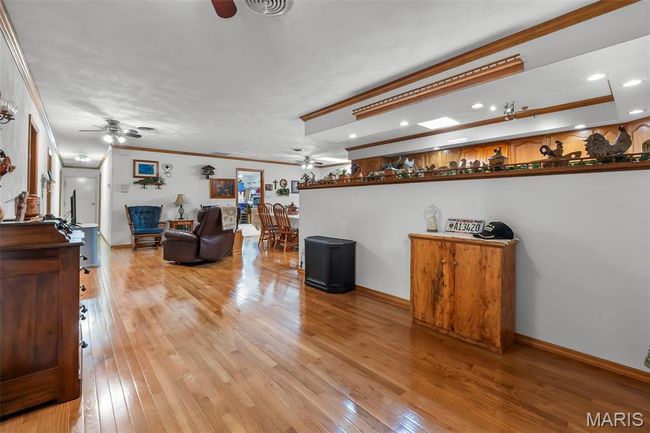 Living room with ceiling fan, ornamental molding, light wood-style floors, and recessed lighting | Image 61
