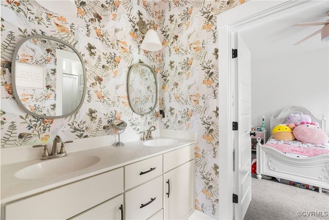 Ensuite bathroom with wallpapered walls, double vanity, a ceiling fan, and baseboards | Image 27