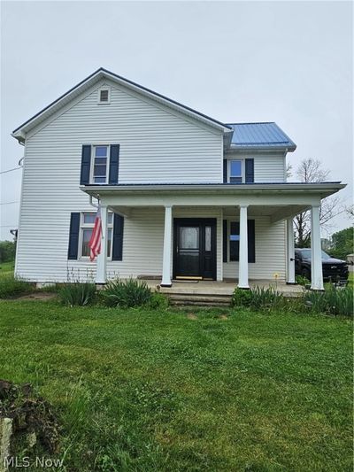 Rear view of house with a lawn and a porch | Image 1