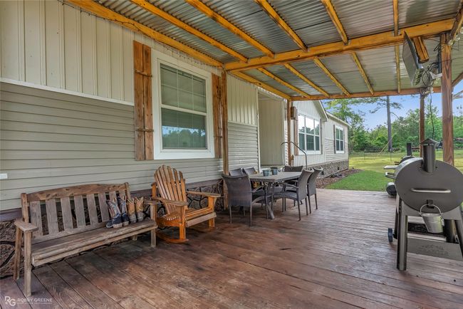 Wooden terrace featuring outdoor dining space and a yard | Image 36