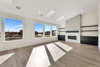 Unfurnished living room featuring lofted ceiling and light hardwood / wood-style flooring | Image 2