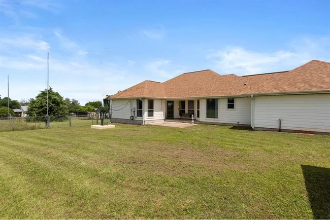 Rear view of property with a patio area and a shingled roof | Image 22