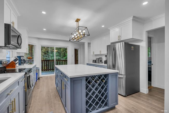Kitchen featuring appliances with stainless steel finishes, white cabinetry, light countertops, recessed lighting, and ornamental molding | Image 14