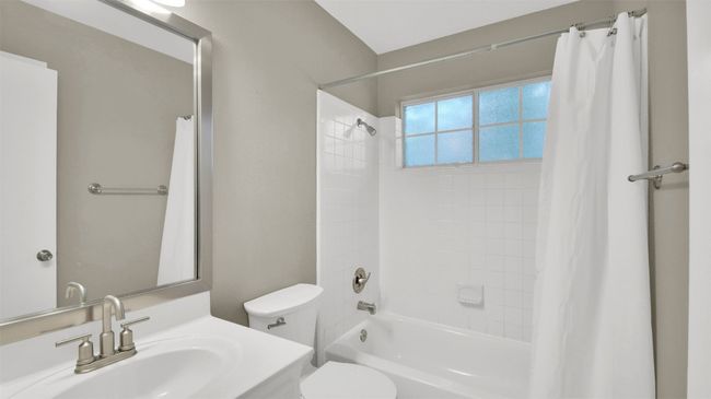 Ensuite bathroom featuring shower / bathtub combination with curtain, vanity, and toilet | Image 16
