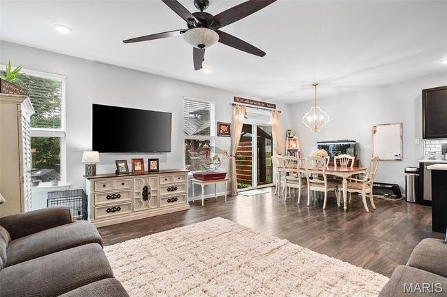 Living room with plenty of natural light, a chandelier, a ceiling fan, dark wood-style flooring, and recessed lighting | Image 6