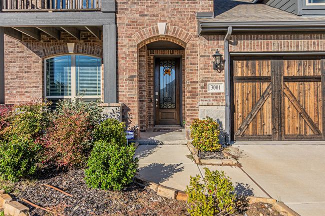 Property entrance featuring brick siding, a shingled roof, and a balcony | Image 4