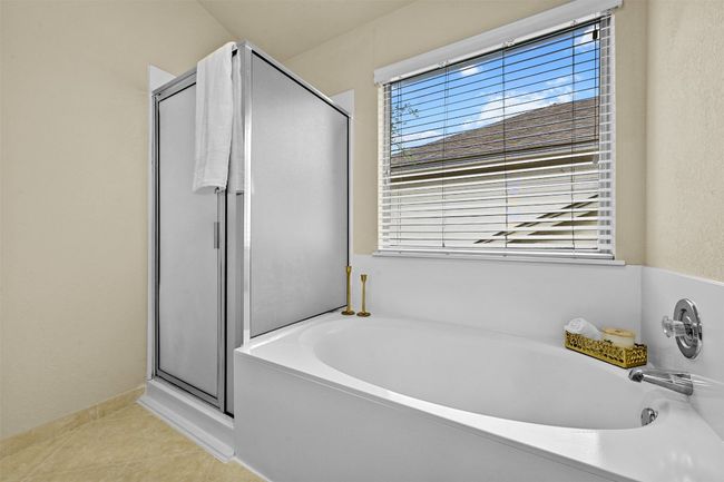 Full bath with a shower stall, a garden tub, and tile patterned floors | Image 25