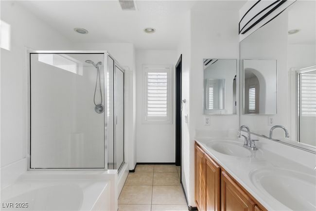 Bathroom featuring double sinks, walk-in shower, soaking tub, and tile patterned floors | Image 16