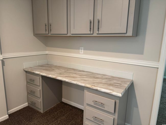 Unfurnished office with built in desk and dark carpet | Image 31