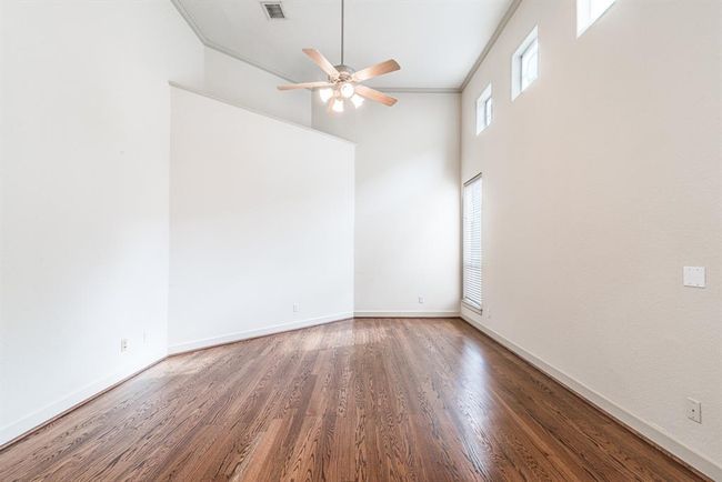 Beautiful wood flooring, crown molding, high ceiling and great light in this primary bedroom. | Image 7