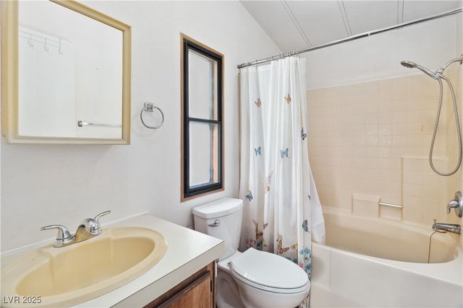 Full bathroom featuring shower / tub combo with curtain, vanity, and toilet | Image 24