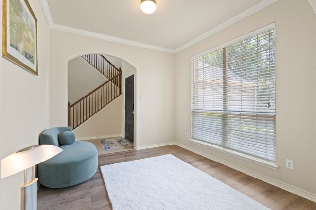 Living area with wood finished floors, stairs, arched walkways, ornamental molding, and baseboards | Image 5