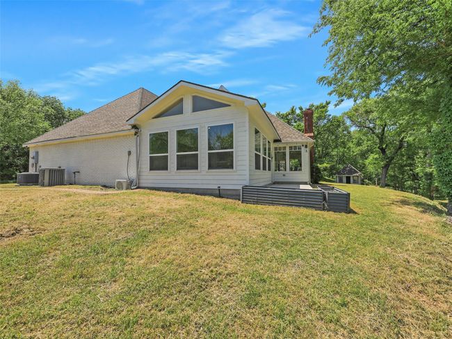 Rear view of house featuring a chimney, roof with shingles, a yard, and central AC unit | Image 28
