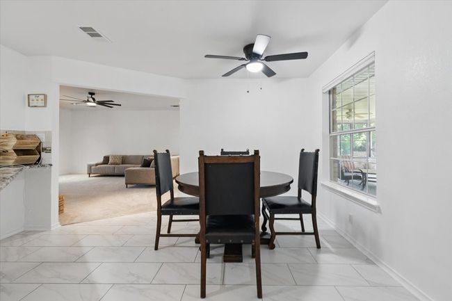 Dining room with light marble finish floors, a ceiling fan, and baseboards | Image 12