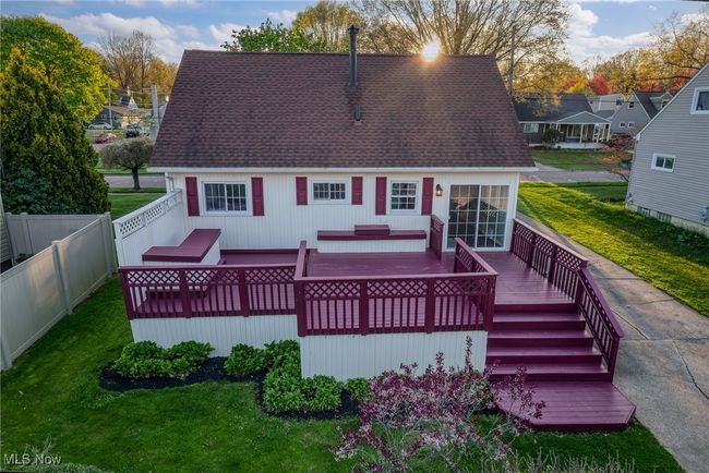 Rear view of house with fence, roof with shingles, a deck, and a lawn | Image 4