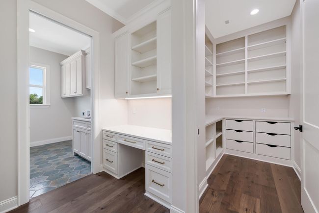 Unfurnished office featuring built in study area, dark wood finished floors, and ornamental molding | Image 23