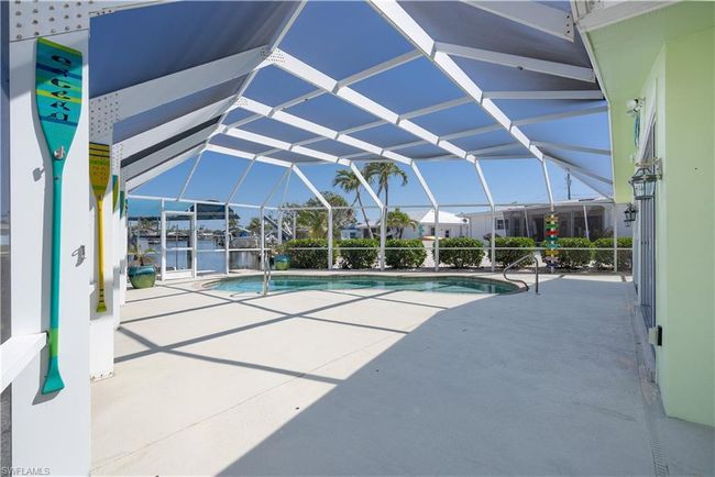 Outdoor pool with a patio area and screen enclosure | Image 18