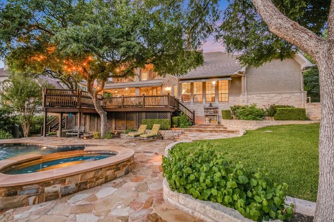 Tranquil view of backyard spa at the pool, storage under the deck and rear of the house. | Image 31