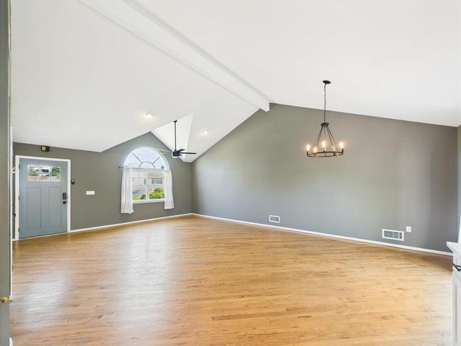 Unfurnished living room featuring a chandelier and light wood-style floors | Image 18
