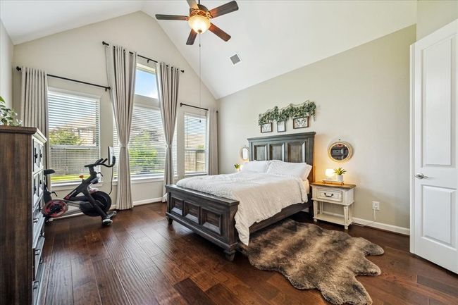 Oversized primary w/ custom drapes & serene bathroom retreat. Notice the vaulted ceilings and views overlooking the backyard. Custom drapes in 2025 and continuous hardwoods throughout the 1st level. | Image 10