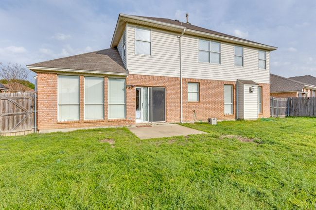Rear view of property with fence, brick siding, and a yard | Image 24