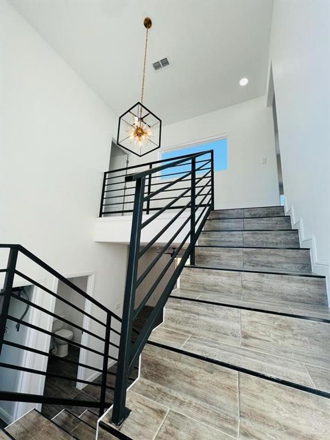 Staircase featuring hardwood / wood-style flooring, a high ceiling, and a notable chandelier | Image 12