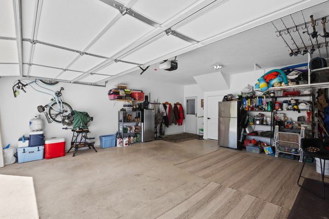 Garage featuring freestanding refrigerator and a garage door opener | Image 34