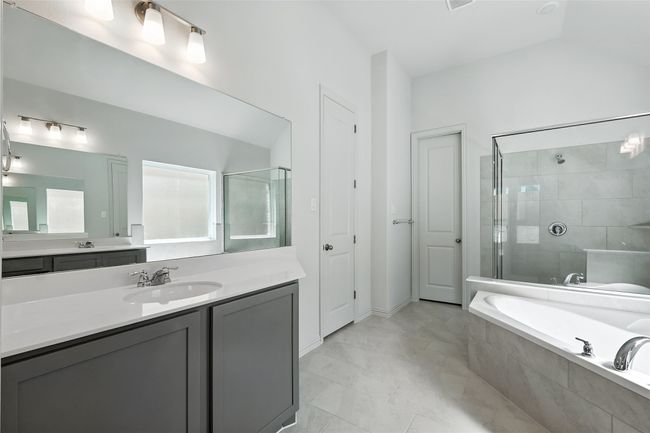 Bathroom with a garden tub, vanity, and a tile shower | Image 23