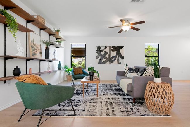 The living room has a modern vibe, filled with natural light and a neutral color scheme, accented with beautiful contrasting black-framed windows. | Image 5