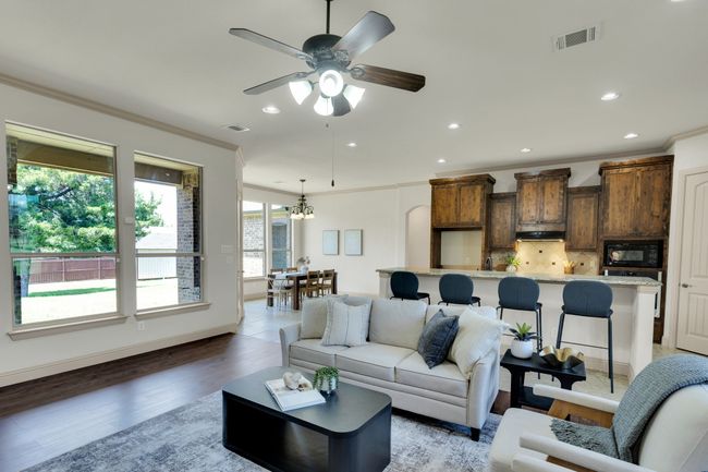 Living area with crown molding, recessed lighting, light wood-style floors, ceiling fan, and a chandelier | Image 4